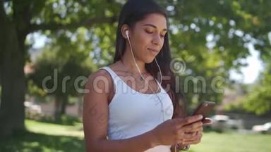 在公园<strong>里</strong>，一个<strong>正在</strong>听音乐的年轻女子<strong>正在</strong>用耳机在智能手机上发短信——快乐